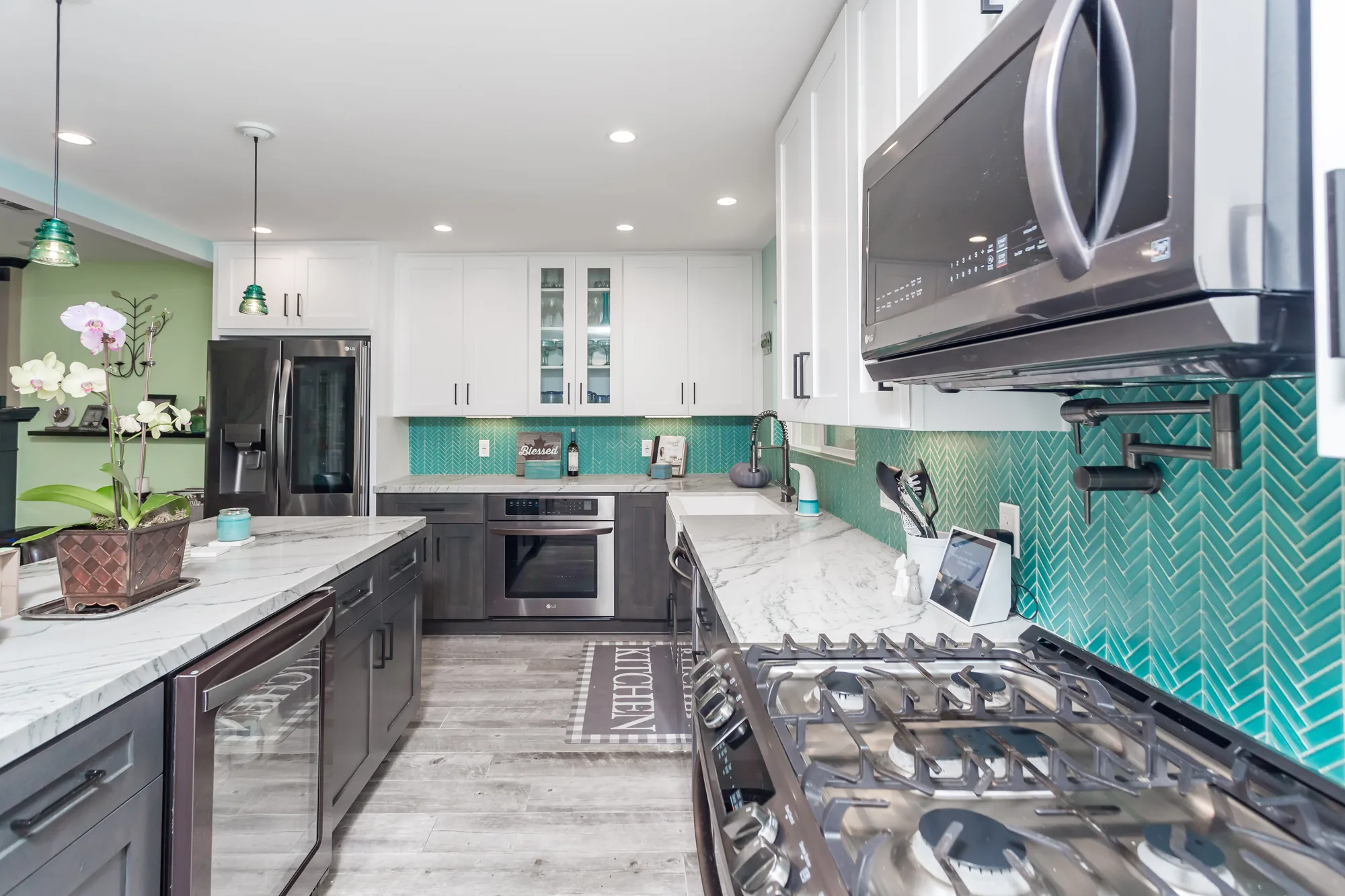 Galley view showing a glass-door beverage cooler, built-in wall oven, and stainless gas cooktop.