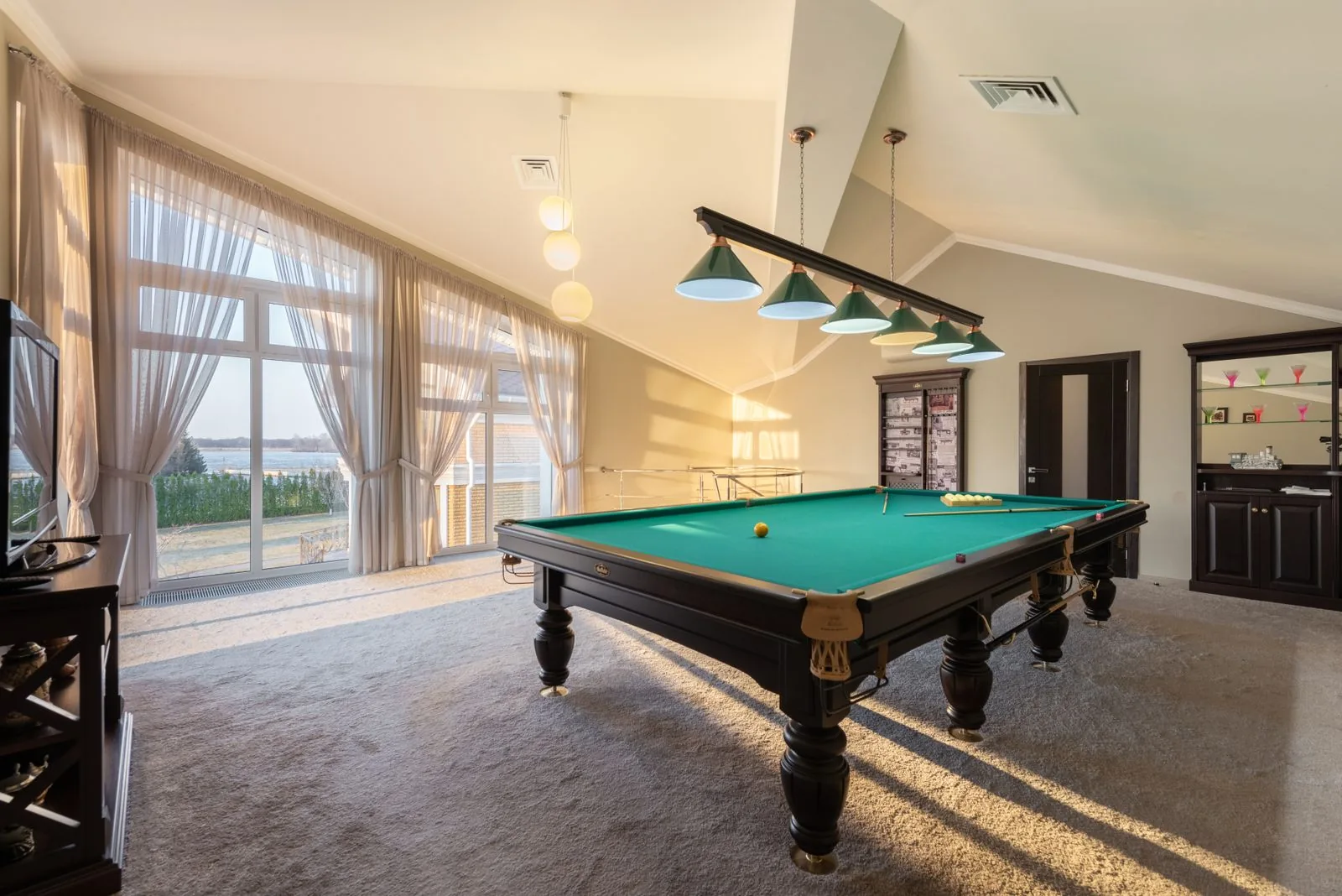 Home game room with a billiards table with clean, modern finishes