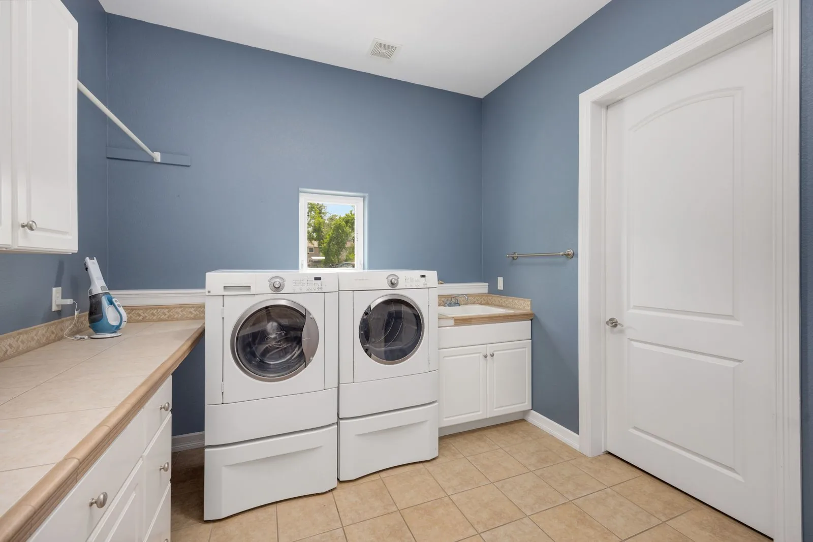 Modern remodeled laundry room with custom cabinetry with natural light