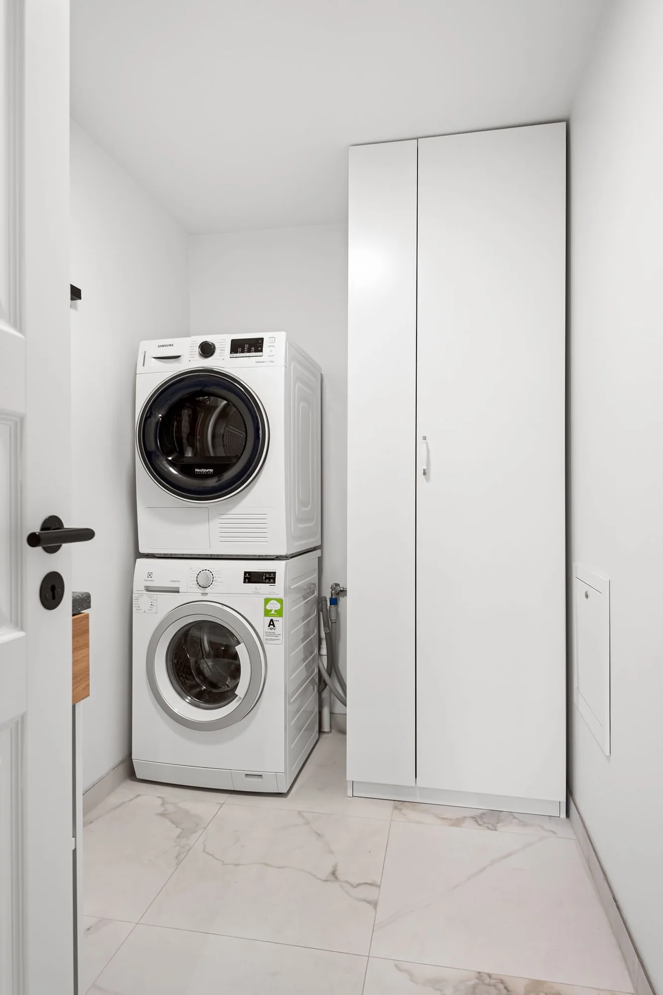 Modern remodeled laundry room with custom cabinetry with clean, modern finishes