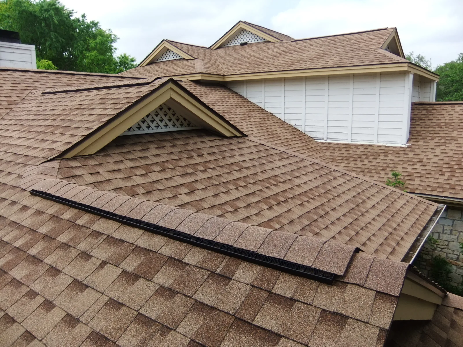Home with complex rooflines and shingle roofing